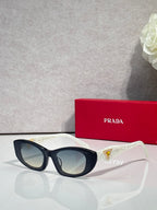 Black cat-eye sunglasses with blue and gold triangular temple accents