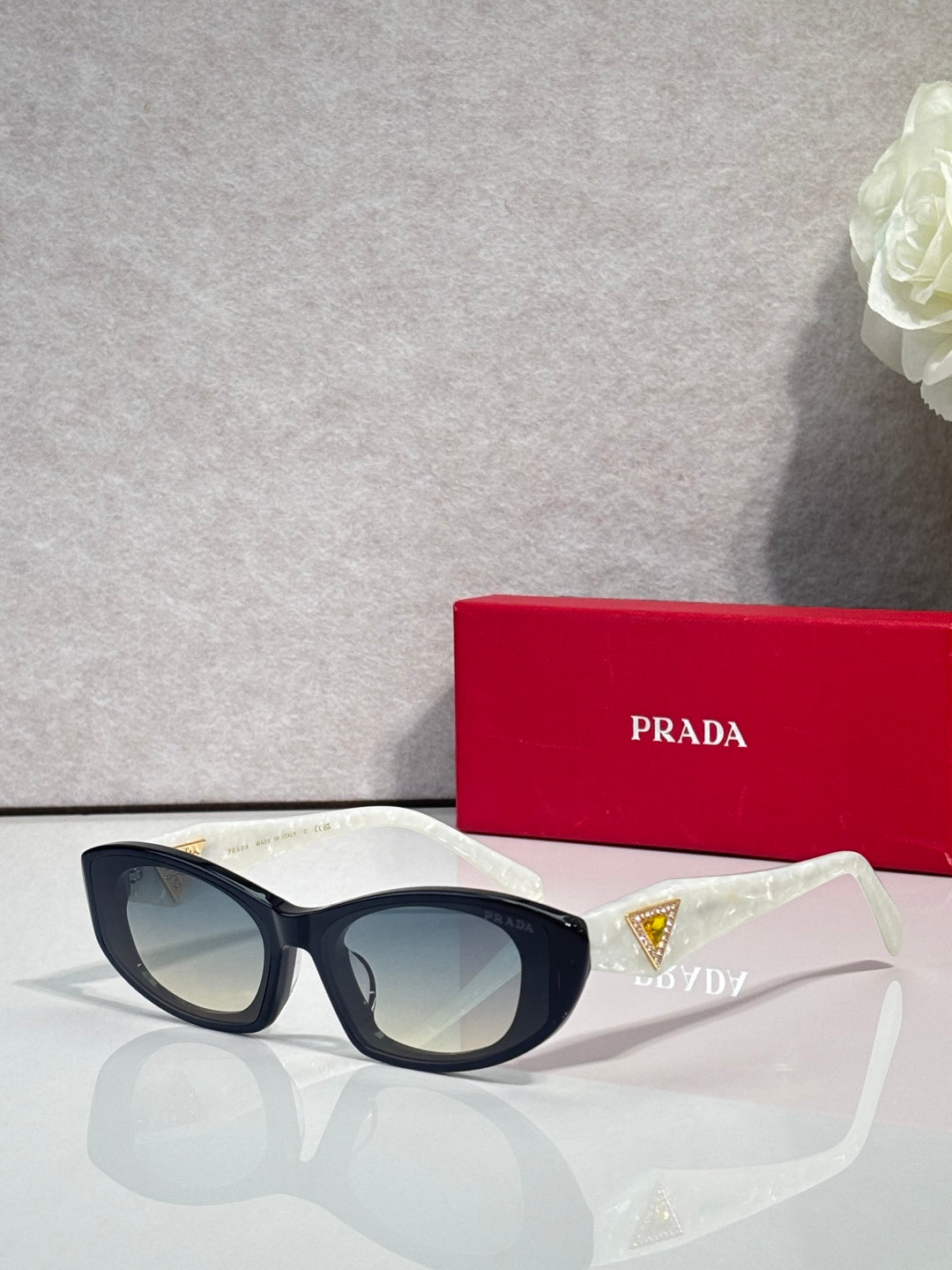 Black cat-eye sunglasses with blue and gold triangular temple accents