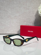Dark green cat-eye sunglasses with gold and blue triangular temple accents