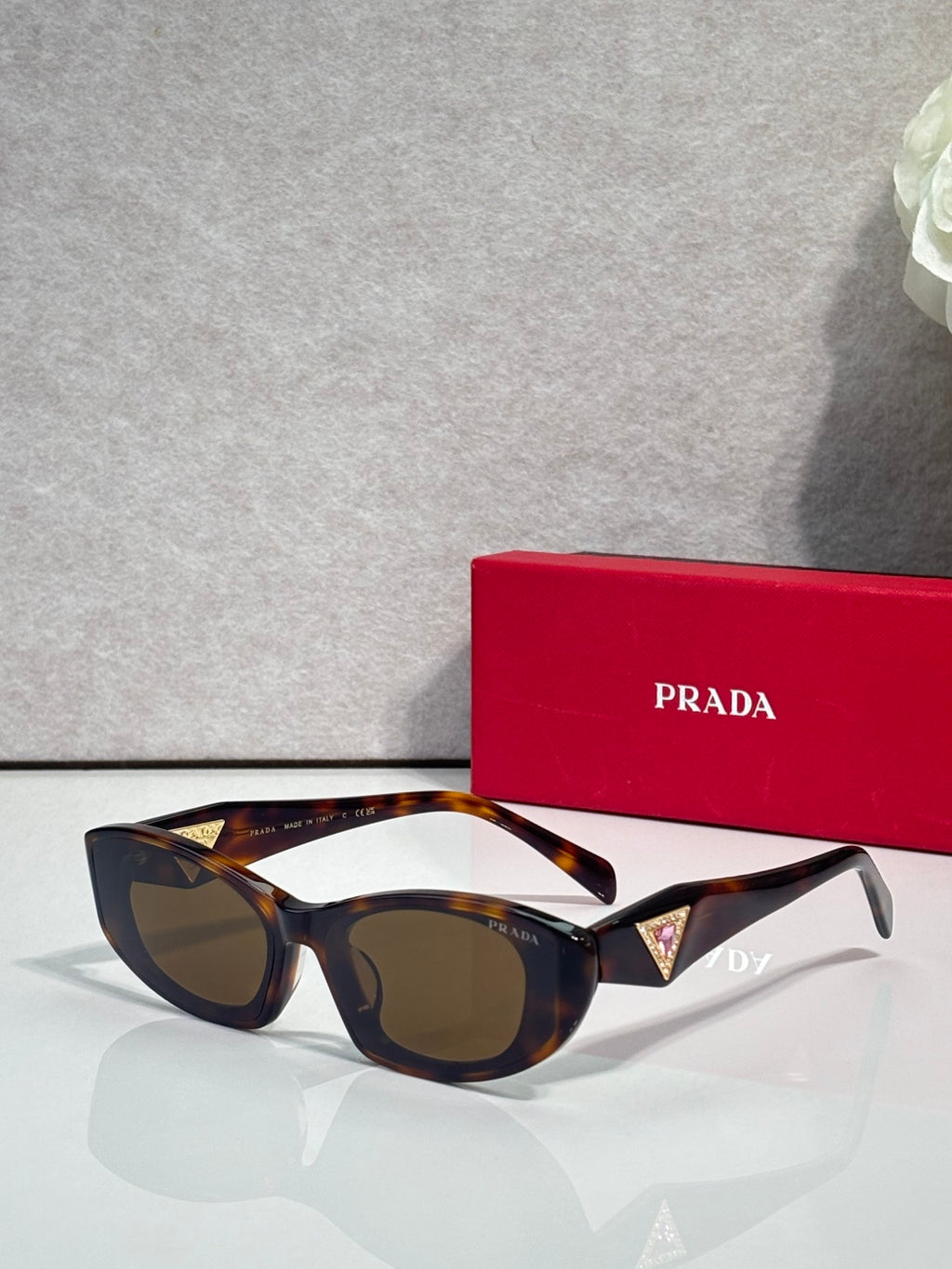 Tortoiseshell cat-eye sunglasses with blue and gold triangular temple accents