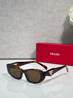 Tortoiseshell cat-eye sunglasses with blue and gold triangular temple accents