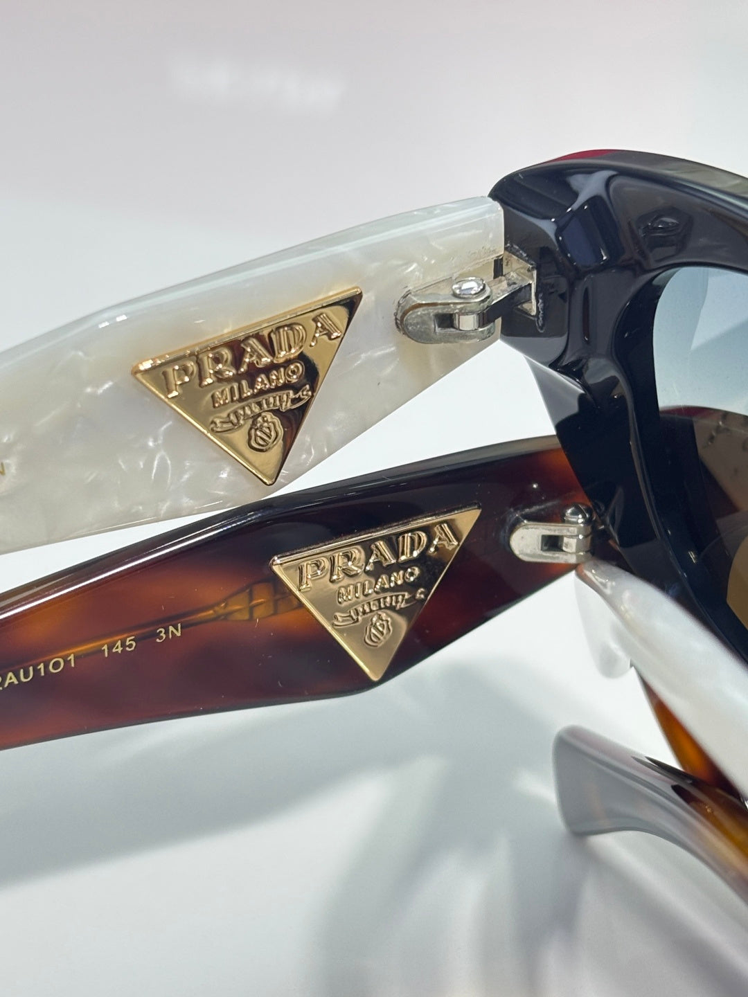 Multi-color cat-eye sunglasses with gold Prada-engraved triangular side details