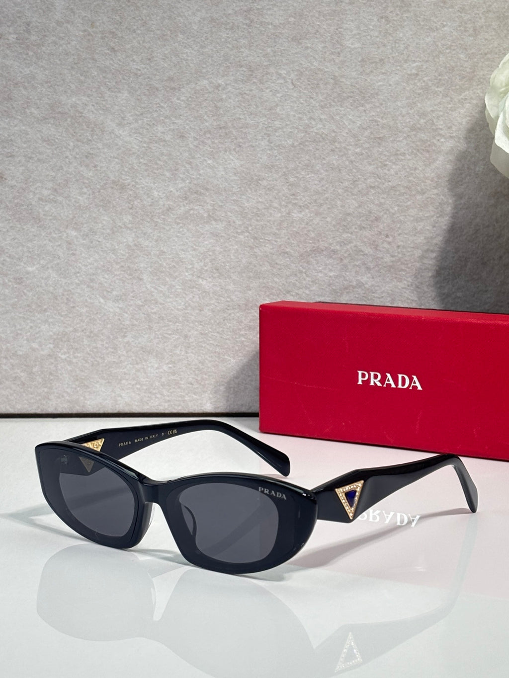 Black cat-eye sunglasses with blue and gold triangular temple accents