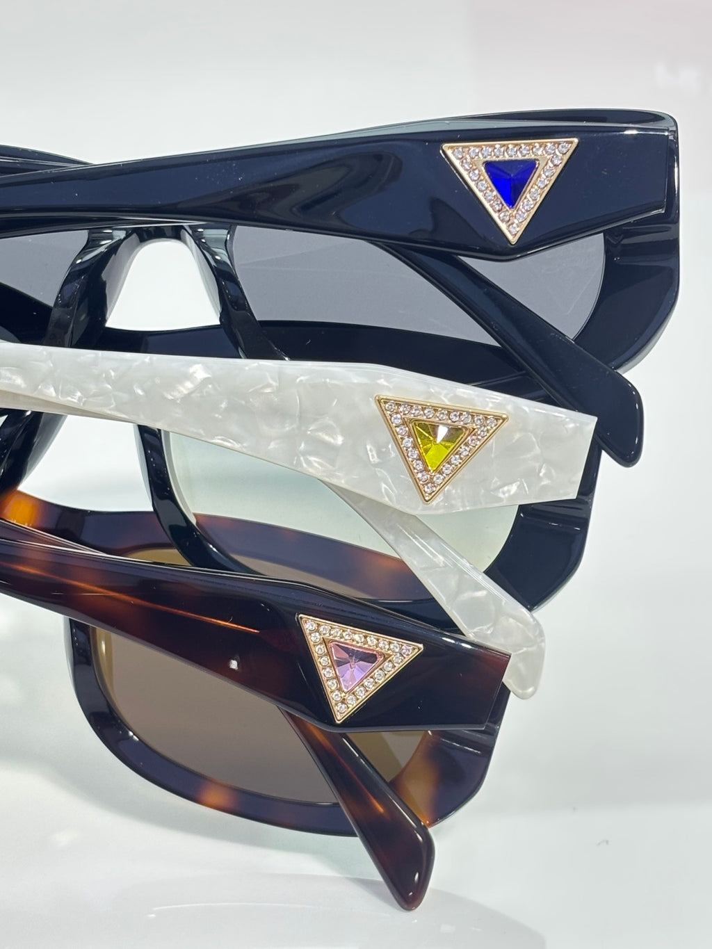 Prada sunglasses detail of front and temples with triangular jeweled logos.