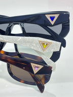 Prada sunglasses detail of front and temples with triangular jeweled logos.