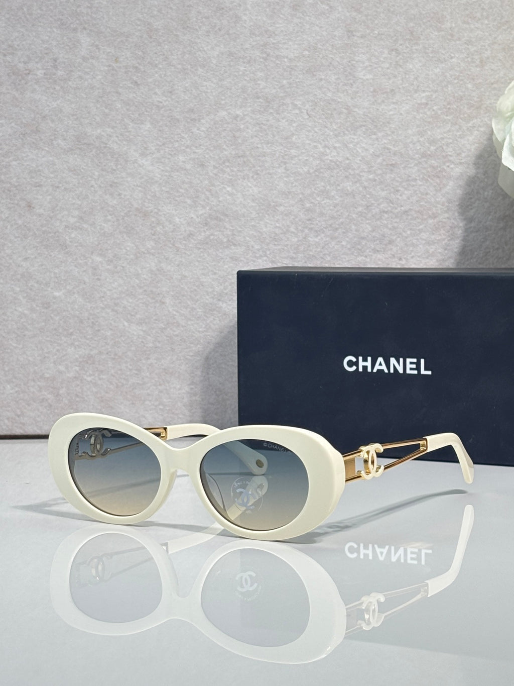 Cream round sunglasses with gold double-C temple detail and tinted lenses