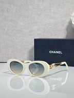 Cream round sunglasses with gold double-C temple detail and tinted lenses