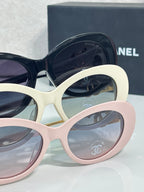 Stacked round sunglasses frames in navy, cream, and pink with tinted lenses