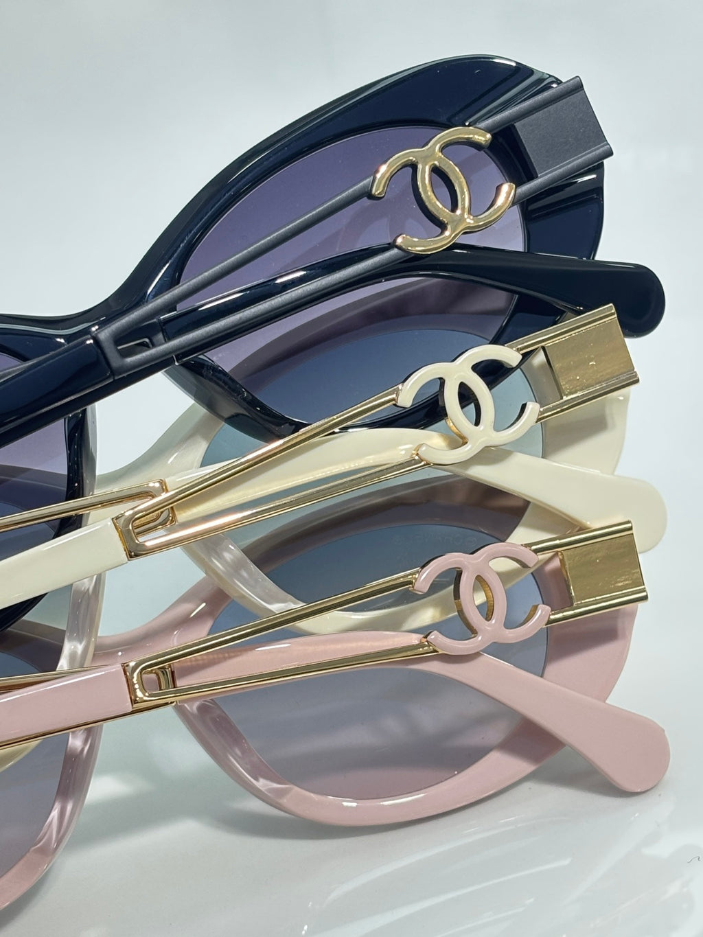 Gold double-C temple details on stacked sunglasses frames with tinted lenses