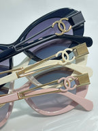 Gold double-C temple details on stacked sunglasses frames with tinted lenses