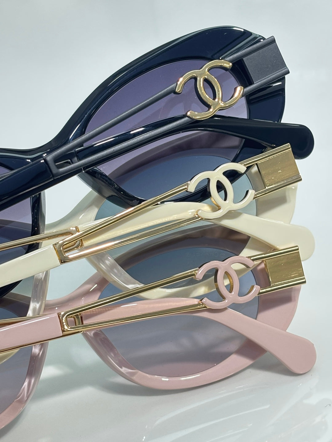 Gold double-C temple details on stacked sunglasses frames with tinted lenses
