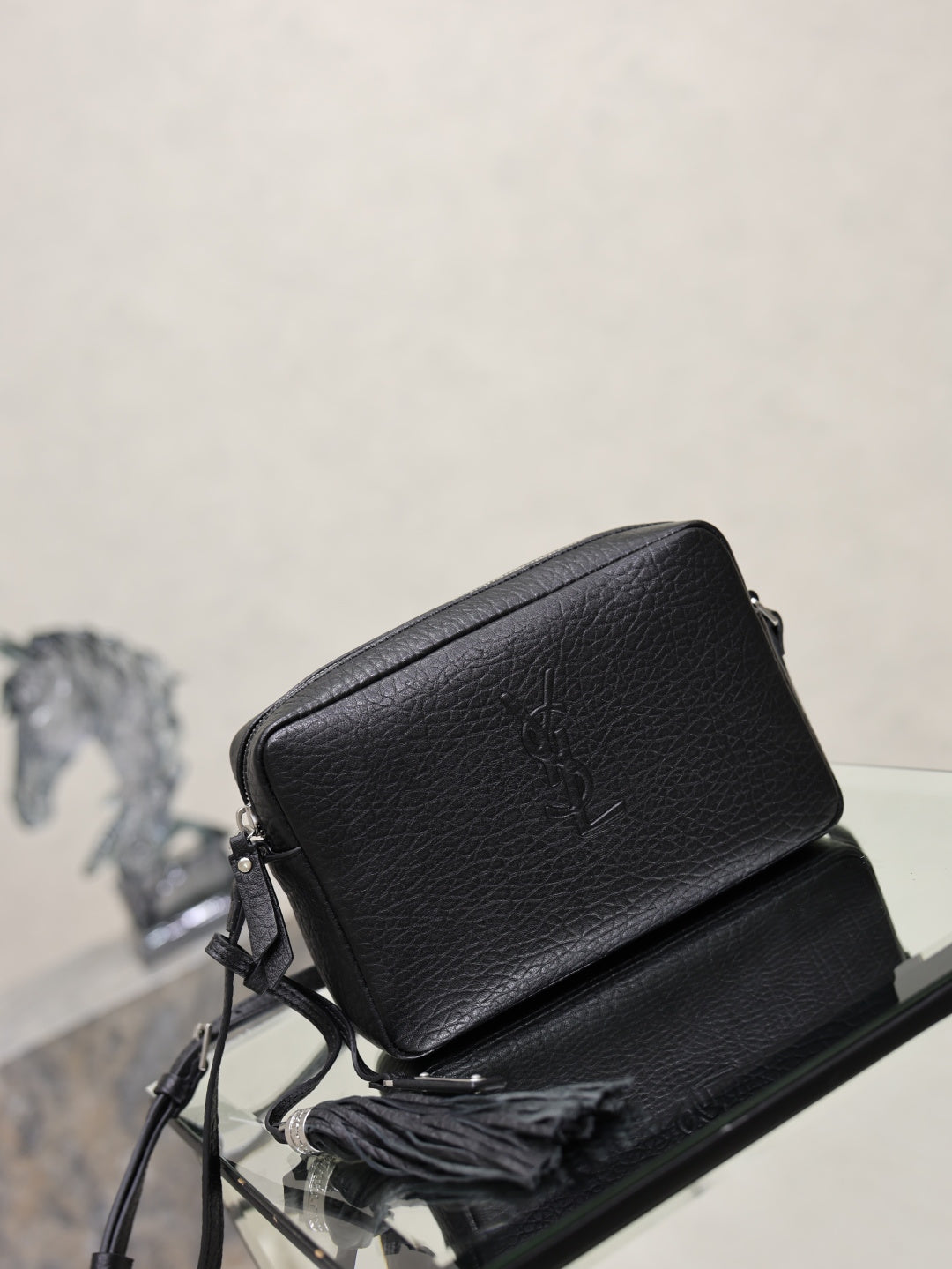 YSL leather crossbody bag in black pebbled finish with YSL logo on the flap.