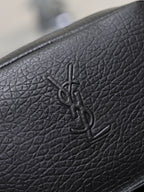 YSL logo embossed on black pebbled leather of a small crossbody bag.