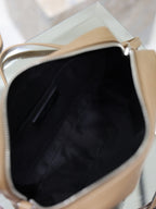 Tan leather YSL bag interior view with zipper opening and black fabric lining.