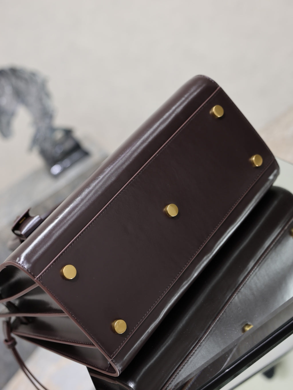 YSL dark brown leather bag with gold-tone stud buttons and side panel detail