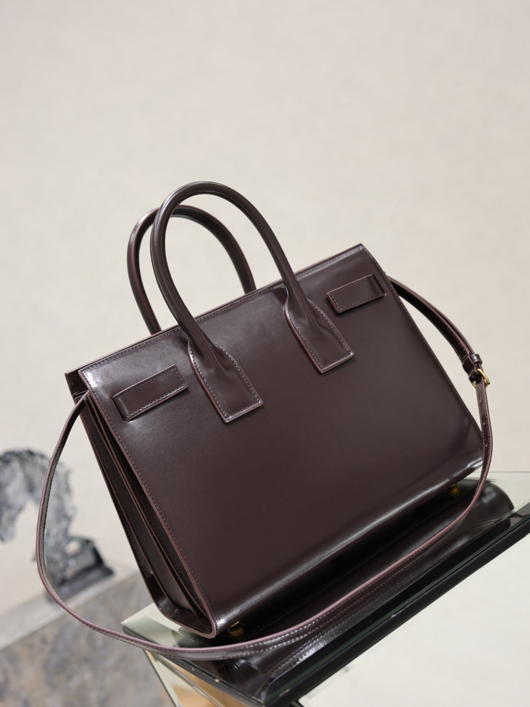 YSL dark brown leather tote bag with shoulder strap, top handles, and front pocket