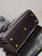Dark brown YSL tote bag side view with gold snap buttons and leather strap