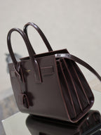 Dark brown YSL structured tote bag with long handles and pleated side panels