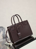 Dark brown YSL tote bag with top handles, front buckled tabs, and strap details