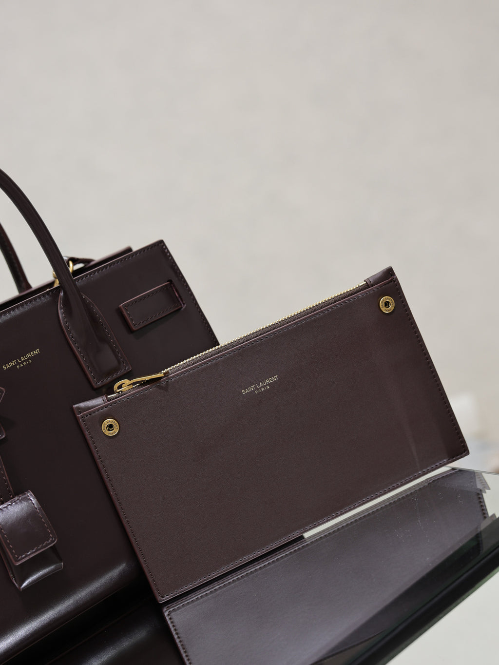 Dark brown YSL tote bag with matching pouch, gold snaps, and front leather tabs