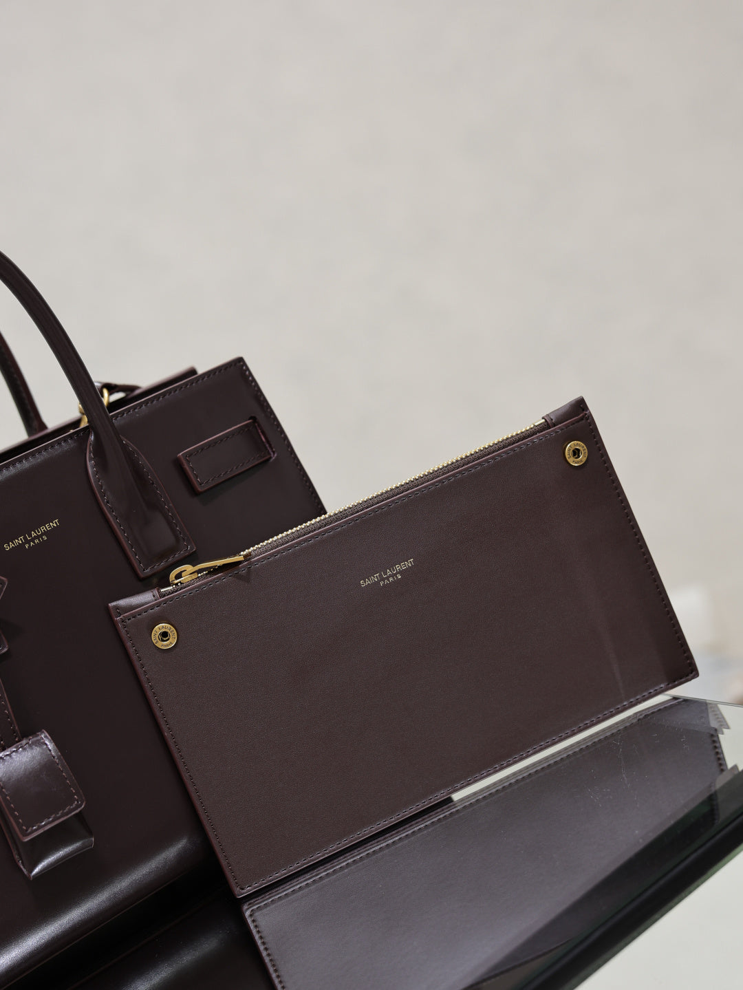 Dark brown YSL tote bag with matching pouch, gold snaps, and front leather tabs