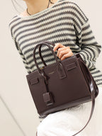 YSL structured leather tote bag with front flap and dangling strap details, dark brown.