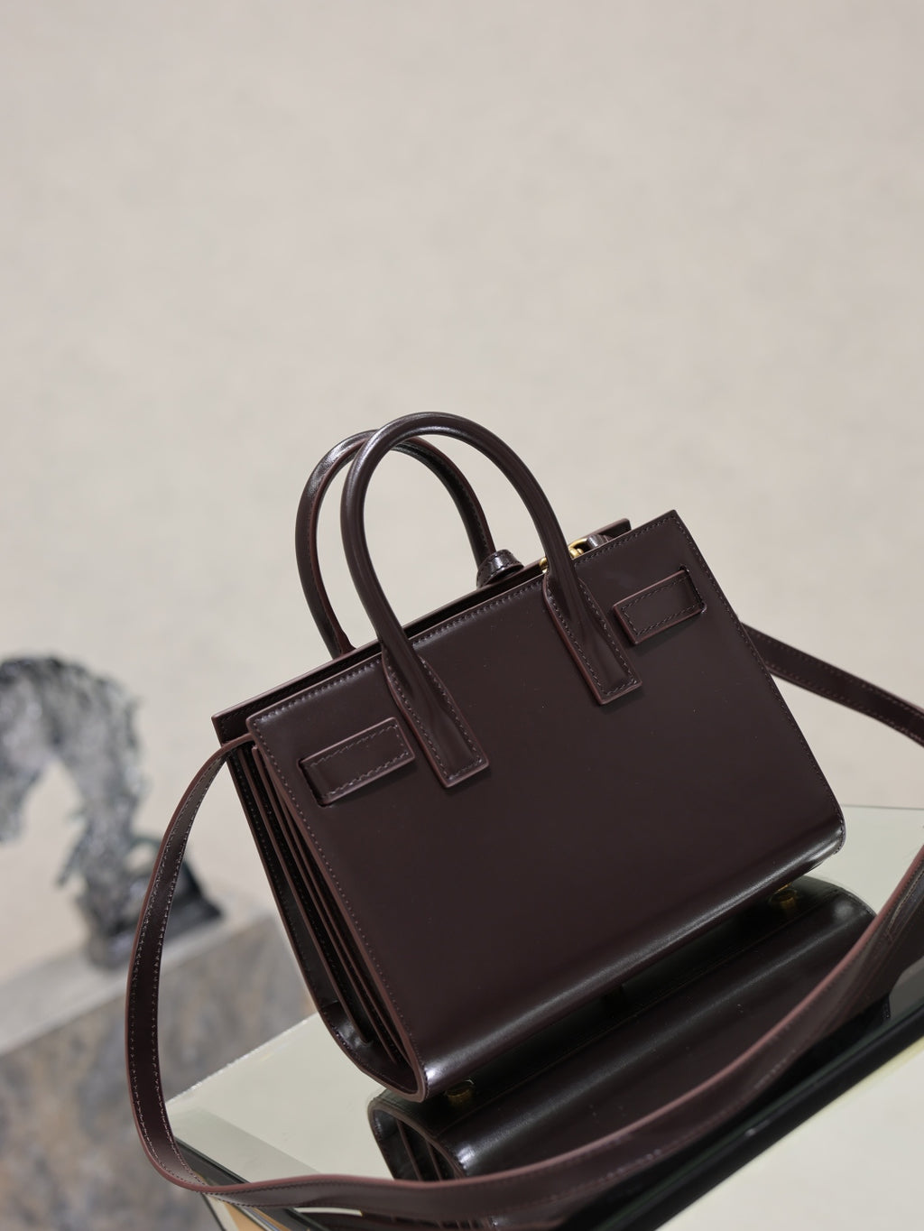 Dark brown leather handbag front view with double handles and structured top frame