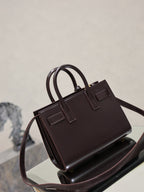 Dark brown leather handbag front view with double handles and structured top frame