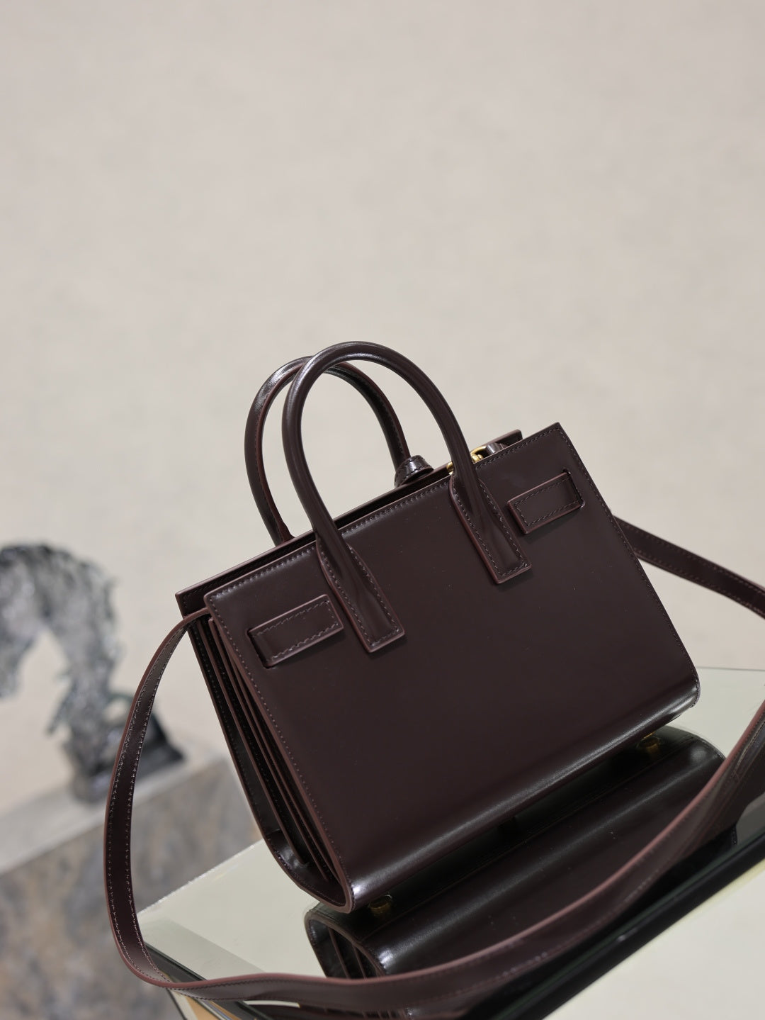 Dark brown leather handbag front view with double handles and structured top frame