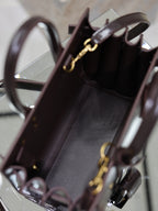 Dark brown leather handbag interior view with gold clasp hardware and top opening