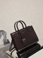 Dark brown leather handbag with double handles, front buckle straps, and side view