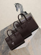 YSL leather tote bag set with front flap and top handles, dark brown.