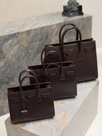 YSL leather tote bag with front buckle detail and top handles, dark brown.
