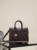 Structured dark brown leather handbag with double top handles and front strap details