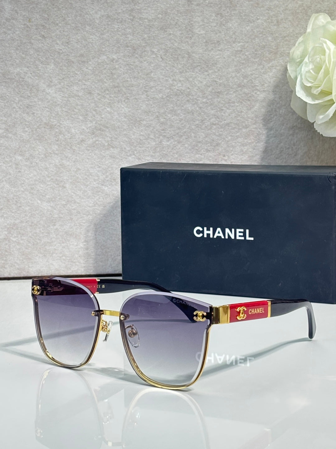 Gold-tone eyeglasses with purple gradient lenses and red top bar detail