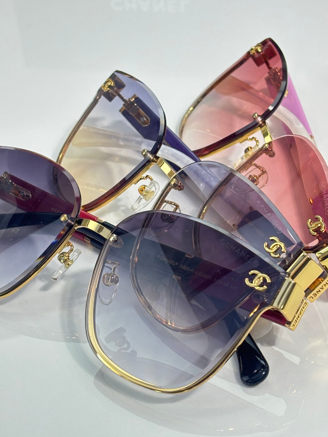 Lavender and pink gradient eyeglasses with gold rims and overlapping tinted lenses