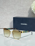 Gold-tone eyeglasses with clear lenses and dark blue temple accents