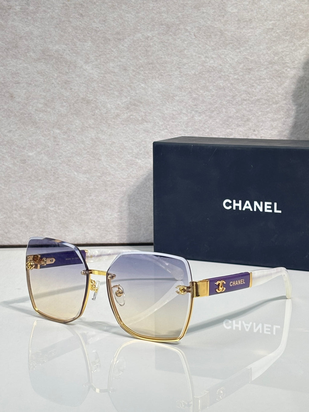 Chanel sunglasses with blue-to-clear gradient lenses and gold-tone frame, CHANEL logo detail