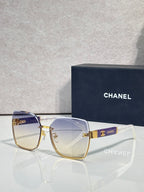 Chanel sunglasses with blue-to-clear gradient lenses and gold-tone frame, CHANEL logo detail