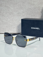 Chanel sunglasses with dark blue gradient lenses and gold-tone frame, logo hardware on temples