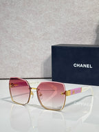 Chanel sunglasses with pink gradient lenses and gold-tone frame, logo hardware on temples