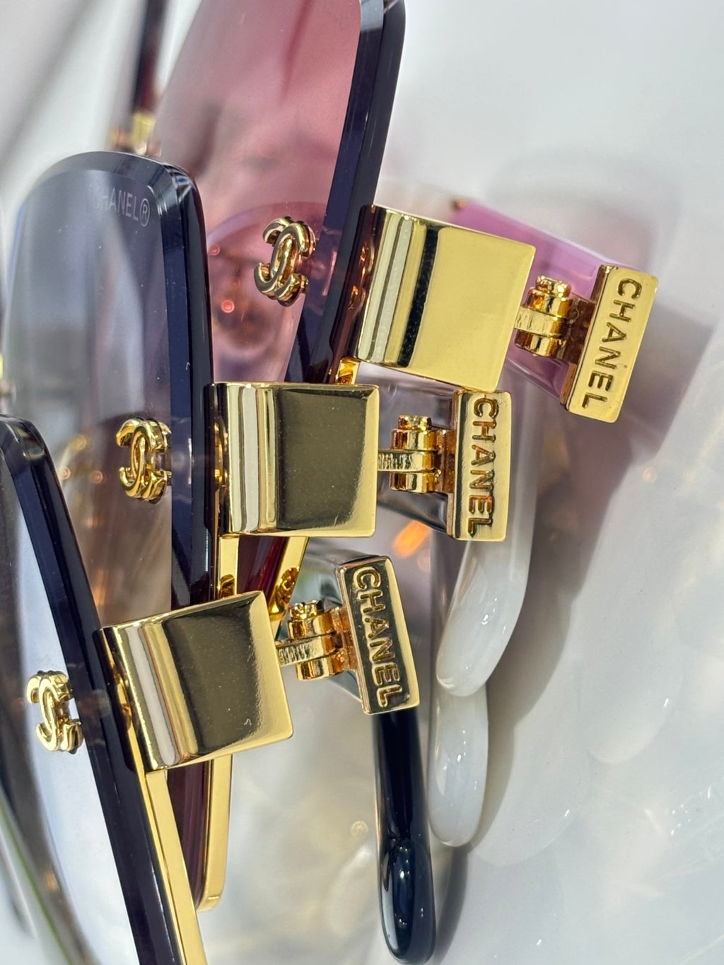 Chanel sunglasses close-up of gold-tone temples and side logos with iridescent lens accents