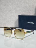 Chanel sunglasses with amber gradient lenses and gold-tone frame, logo hardware at temple