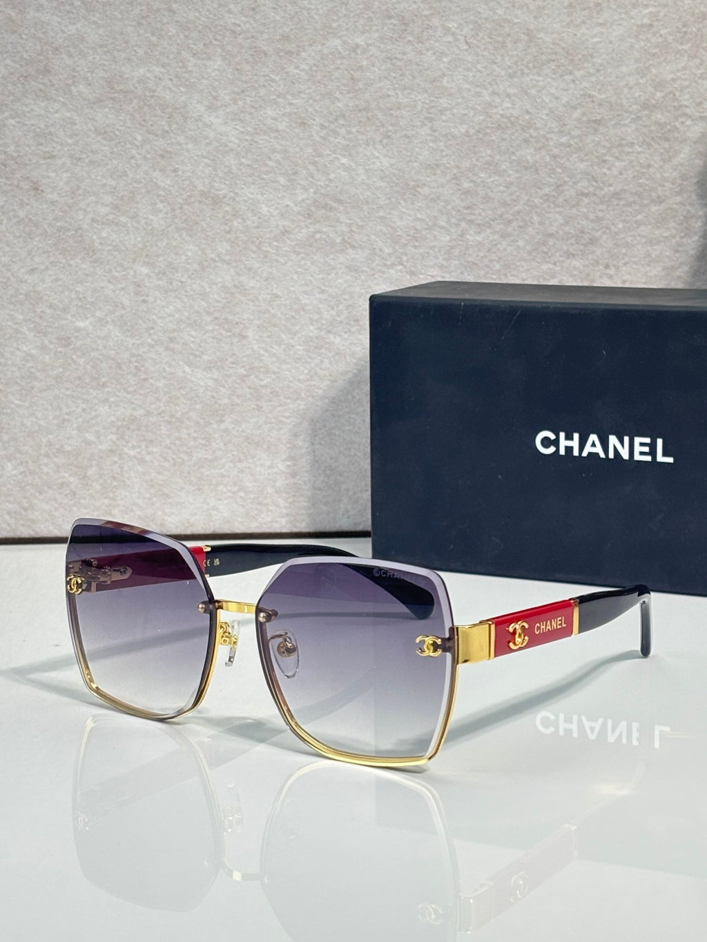 Chanel sunglasses with purple gradient lenses and gold-tone frame, logo medallion on bridge