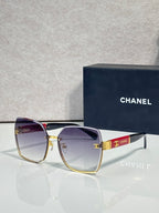 Chanel sunglasses with purple gradient lenses and gold-tone frame, logo medallion on bridge