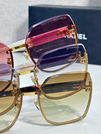 Chanel sunglasses close-up with purple and clear lenses, gold-tone frame and side logos