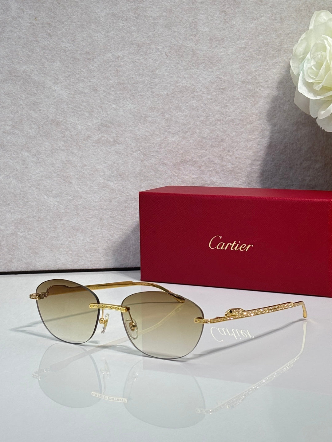 Gold-tone metal sunglasses with light brown lenses and round-oval shape