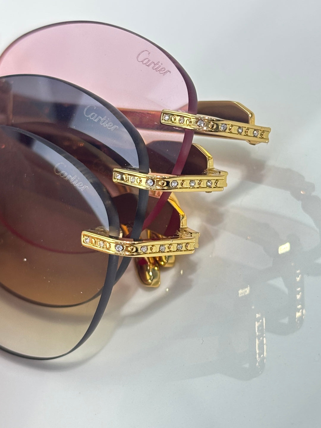 Gold-tone sunglasses closeup with jeweled temple details and tinted lenses
