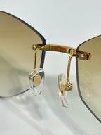 Gold-tone eyeglasses with clear lens accents and metal hinge detail