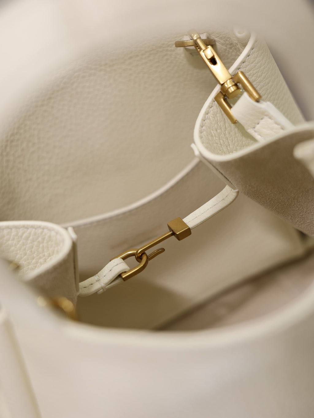 YSL bag cream leather with gold buckle and adjustable strap hardware, close-up detail.